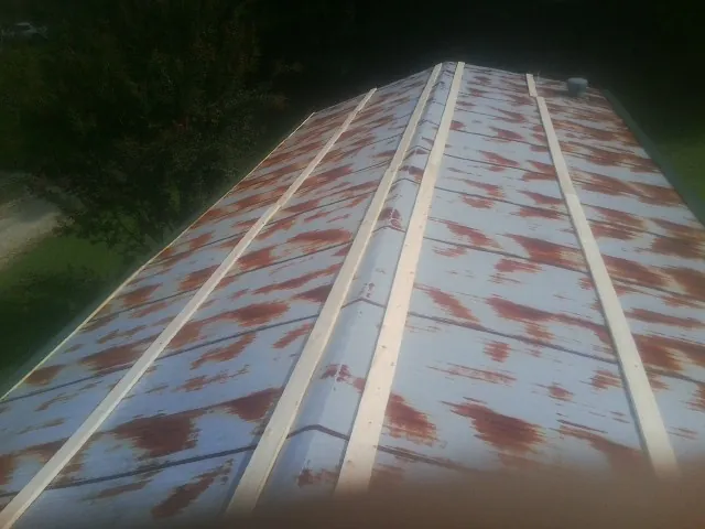 Rusted metal roof panels with new wood purlins before replacement — Storm Damage Roof Repair in Plainview by Roofing Brothers