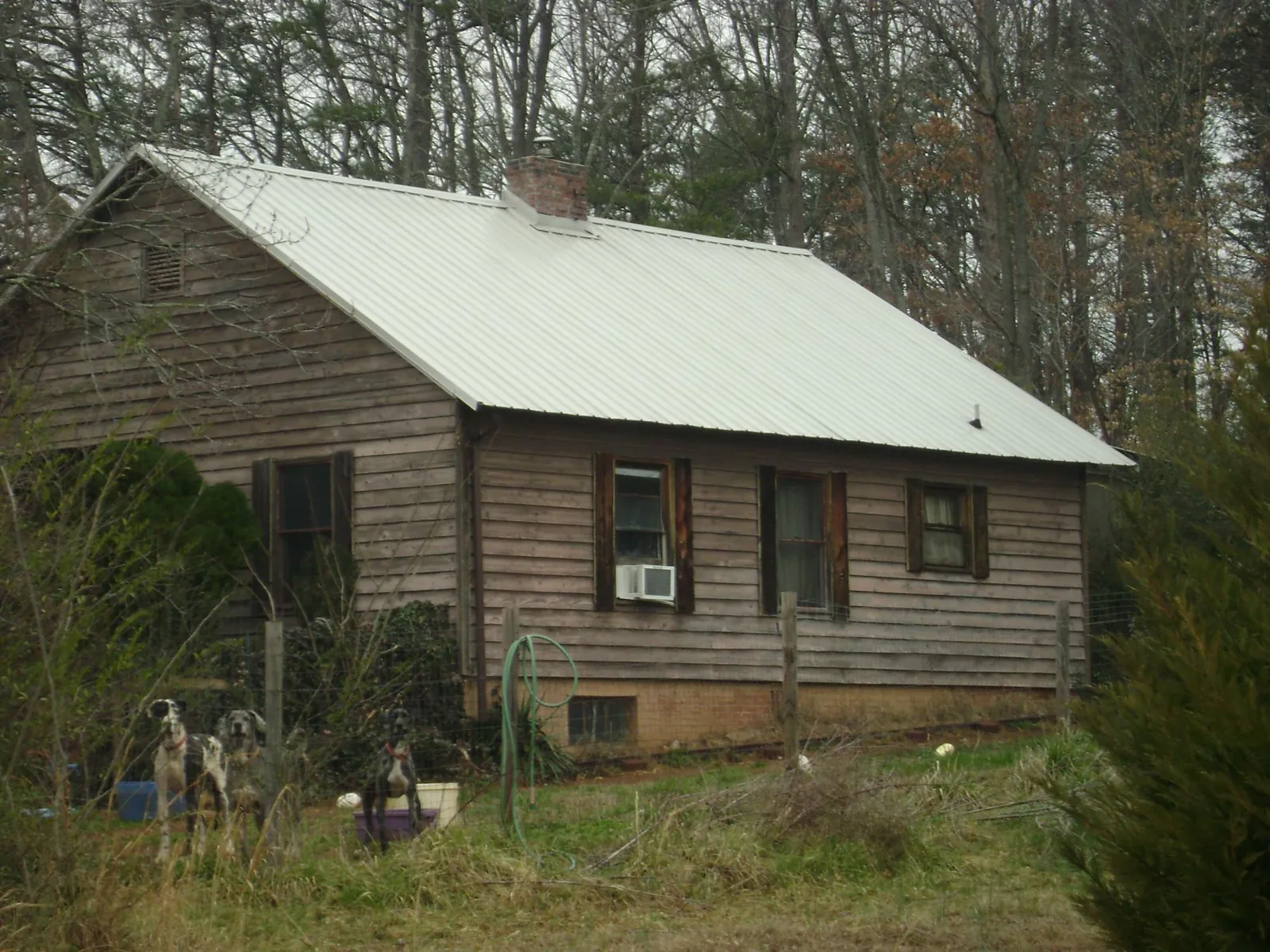 White metal roof on an old wood sided farmhouse, from a Metal Roof Installation job in Plainview